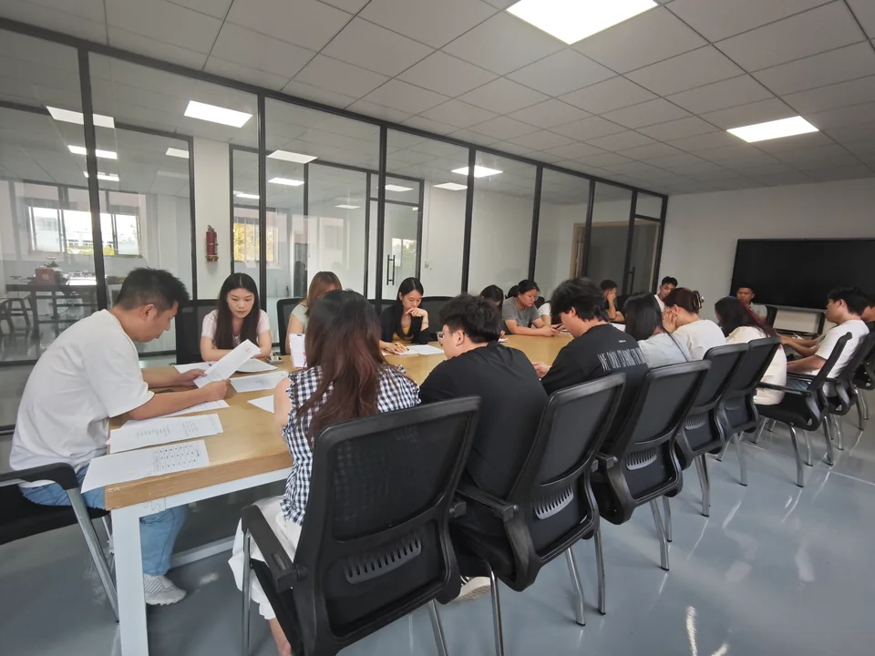 A team meeting at YiTuo YiTuo colleagues meeting around a table with paperwork in the office.