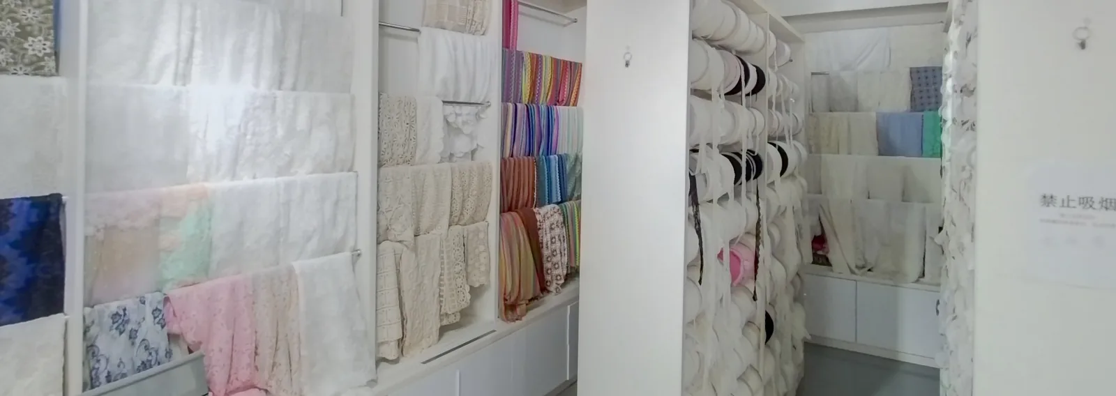 YiTuo sample showroom Lace samples displayed on wall panels and roll racks in YiTuo’s sample showroom.